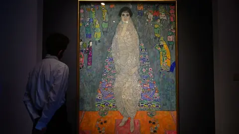 A man looks at Gustav Klimt's Portrait of Elisabeth Lederer with his hands behind his back.