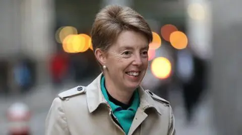 Getty Paula Vennells is seen smiling and walking outdoors in 2018