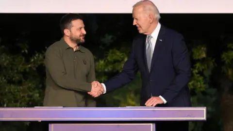 EPA-EFE/REX/Shutterstock Ukrainian President Volodymyr Zelensky (left) and his US counterpart Joe Biden shake hands after signing a bilateral security deal at the G7 summit in Italy. Photo: 13 June 2024