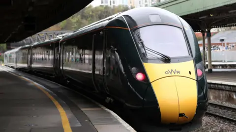 A GWR yellow and black train at a station