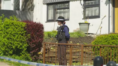Police officer stands at the cordon near where the body was found on an estate at Trevethin, Pontypool