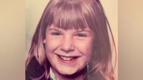 Heidi Clutterbuck The picture shows Heidi aged 9 to 10. She has shoulder length brown hair and a big smile.