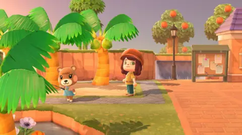 Animal Crossing: New Horizons, Nintendo EPD Une capture d'écran du jeu Animal Crossing, montrant le personnage d'un joueur sur une place de la ville, regardant un ours pêcher dans un étang. Ils sont entourés de palmiers et d'orangers.