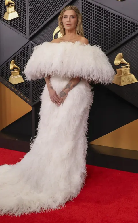 Getty Images Kesha luce un vestido blanco esponjoso mientras posa para una foto en la alfombra roja de los Premios Grammy.