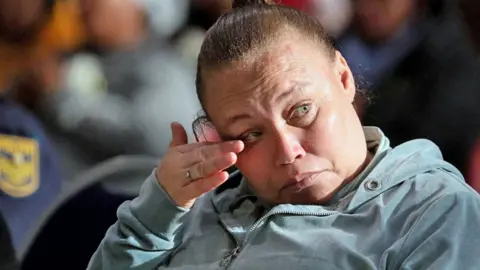 Reuters Racquel Smith, also known as Kelly Smith, wearing grey tracksuit wipes her eye during her sentencing at the Western Cape High Court in Saldanha Bay, South Africa - 29 May 2025.