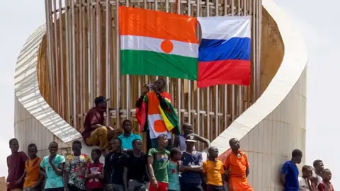 Issifou Djibo/EPA-EFE/REX/Shutterstock Demonstrators display the flags of Niger and Russia during a protest in Niamey, Niger, 30 July 2023.