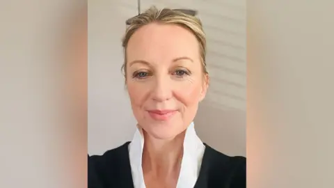 Clare Curran A woman with blonde hair looking directly at the camera, she is wearing a black suit and white shirt