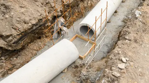 Getty Images Large sewage concrete pipes in a trench on a building site