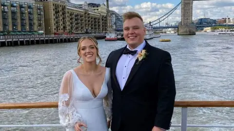 Hannah and Max Hannah and Max smiling on their wedding day in front of Tower Bridge