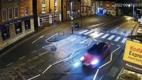 Humberside Police A CCTV image of a red car travelling southbound through a market town High Street