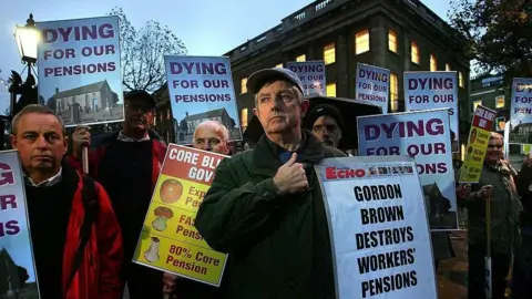 Getty Images A group of men protesting in central London holding signs saying "Gordon Brown destroys workers' pensions" and "dying for our pensions".