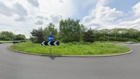 A roundabout dominates this generic photo. There are trees and cars in the background.