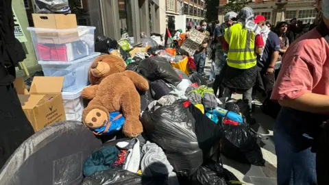 Annabelle Bin bags and belongings of encampment protestors outside building