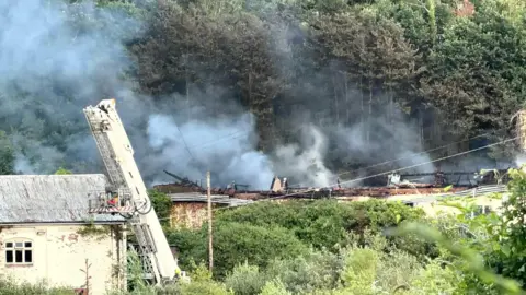Nathan Hunter A large amount of smoke is billowing from an old building.