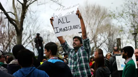 Getty Images Muthumalla Dhandapani, seorang imigran India dengan visa H1-B dan seorang karyawan Comcast di Sunnyvale, memprotes perintah imigrasi Presiden Trump pada tahun 2017.