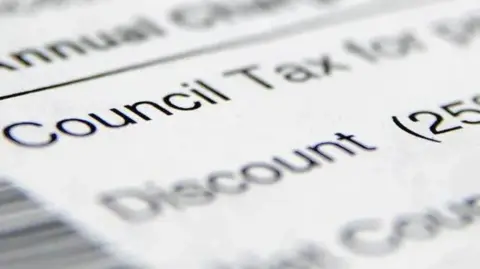 A blurred image of a council tax bill with black ink on white paper