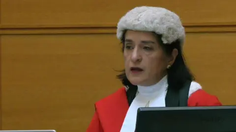 Justice Cheema-Grubb, wearing a periwig and robes, delivers her sentencing remarks to Daniel Khalife at Woolwich Crown Court