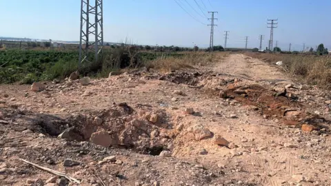 Kraters van twee bommen snijden een weg nabij Jenin.  De bommen raakten twee Israëlische eenheden.