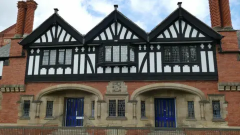 Stephen Craven/Geograph A black and white building with blue doors