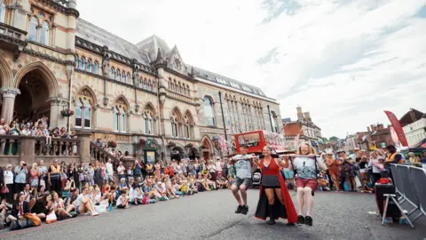 Adrienne Photography / Hat Fair Arts performers in the streets of Winchester surrounded by an audience of people watching them