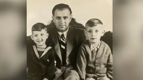 A photograph taken shortly after the war's end showing Peter Herke and his younger brother flanking their father.
