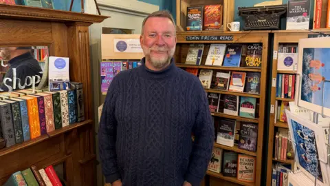 A man in front of a display of books