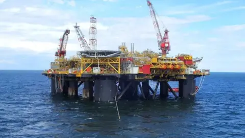 A floating production facility with large legs, in the sea.