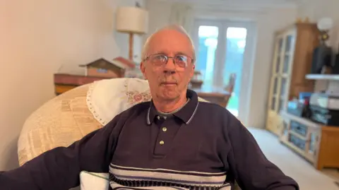 Mike Davies sitting in his chair at home