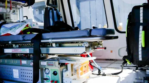 Cornwall Air Ambulance A blue stretcher with monitor equipment under it inside a helicopter.