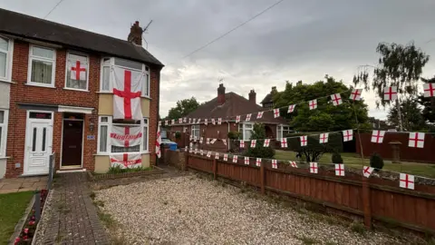 Luke Deal/BBC A residential home in Ipswich covered in England flags and bunting. 