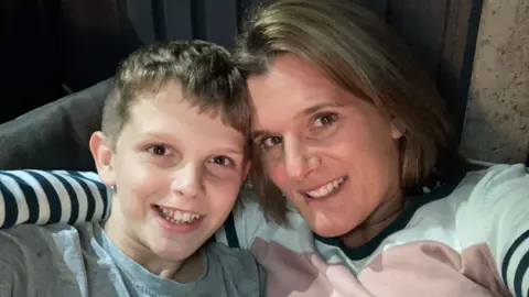 Handout Jools, 14 with his mum Ellen Roome's arm around him while they both smile at the camera in a selfie.