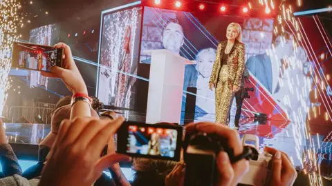 Getty Images Erika Kirk enters the stage for Turning Point's America Fest conference in Phoenix, Arizona
