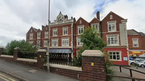 A Google street view image showing the Crewe Arms Hotel - a large three-storey, 19th Century building. A car park can be seen to the right.
