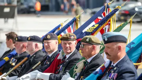 Stockton-on-Tees Borough Council Six veteran service men wearing berets and holding flags representing their units.