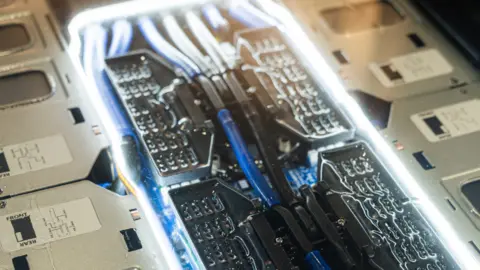 Iceotope Pipework around computer chips some blue and some bright white.