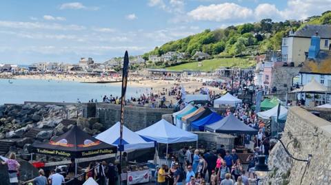 People browsing food festival stalls on Lyme Regis seafront