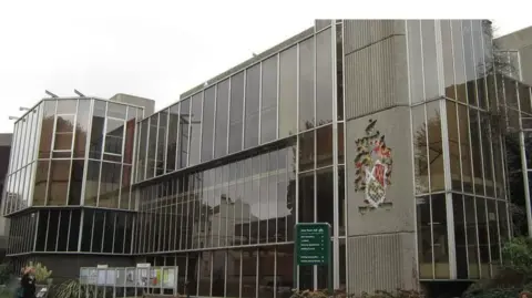 An external view of Hove Town Hall, a brutalist structure of straight angles, concrete and glass.