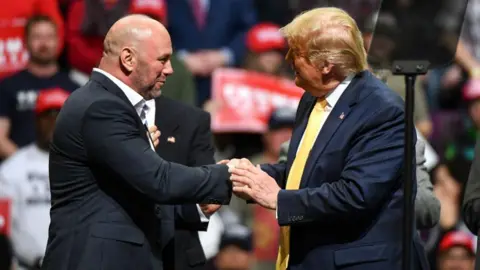 Dana White shakes hands with Donald Trump at a campaign rally in 2020