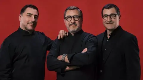 Macallan Joan, Josep and Jordi - all are dressed in black and looking into the camera, with a red backdrop behind them saying The MacAllan Timespirit name