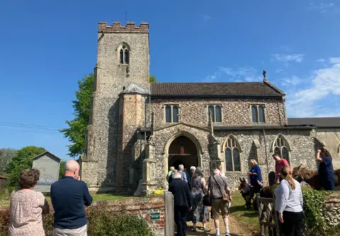 Jack Maclean/BBC St Andrews Church Little Massingham, with people in foreground en route into the church