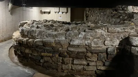 The remains of a medieval defensive tower, a round solid stone structure.