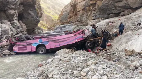A bus badly damaged after crashing into a ravine