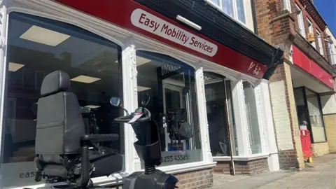 A mobility scooter sits outside the new reopened Easy Mobility Services