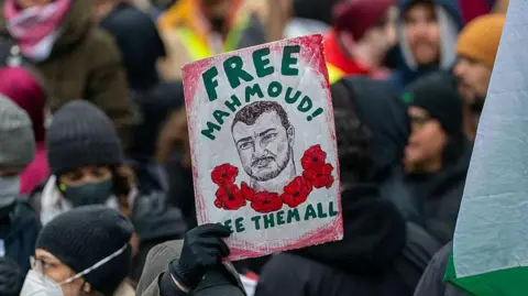 A person holds a sign saying 'Free Mahmoud!' at a demonstration in support of Mahmoud Khalil in Times Square in New York in April