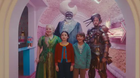 Entertainment Film Distributors Five characters from The Magic Faraway Tree, including two children and a man dressed in a suit made of saucepans