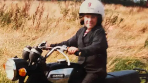 Young Claire on a motorbike.