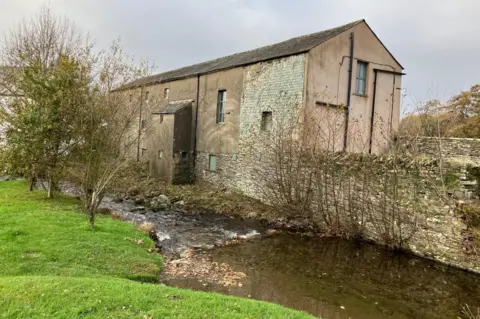 Yew Tree Hall Yew Tree Hall is a three-storey building, with a black slate roof, in a state of disrepair. A beck flows beside it.