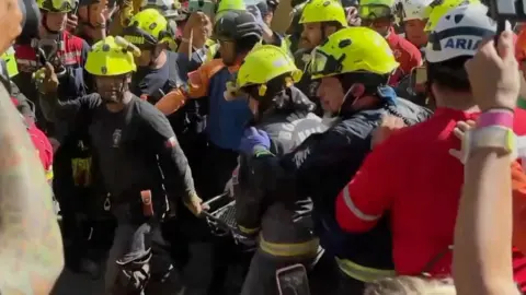 Group of rescuers holding man on stretcher 