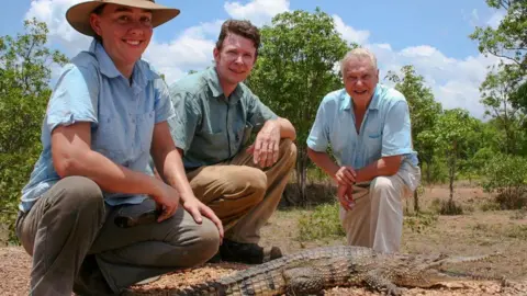 BBC Erin and Adam Britton pose with David Attenborough and a crocodile