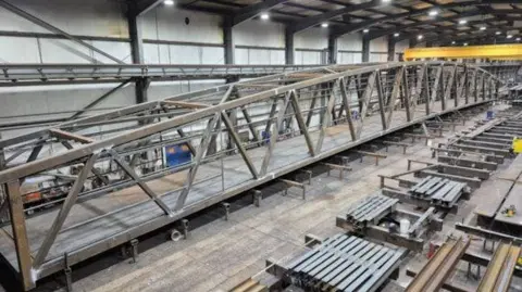National Highways A grey steel bridge in a warehouse.